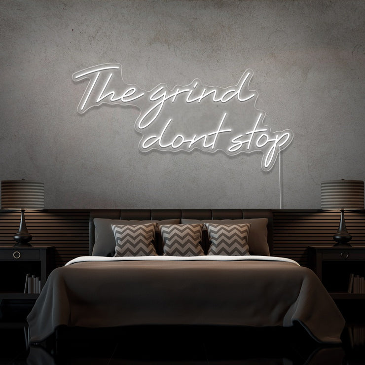 cold white the grind dont stop neon sign hanging on bedroom wall