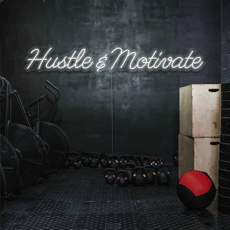 cold white hustle and motivate neon sign hanging on gym wall