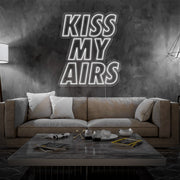 cold white kiss my airs neon sign hanging on living room wall