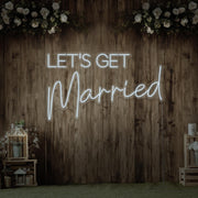 cold white lets get married neon sign hanging on timber wall