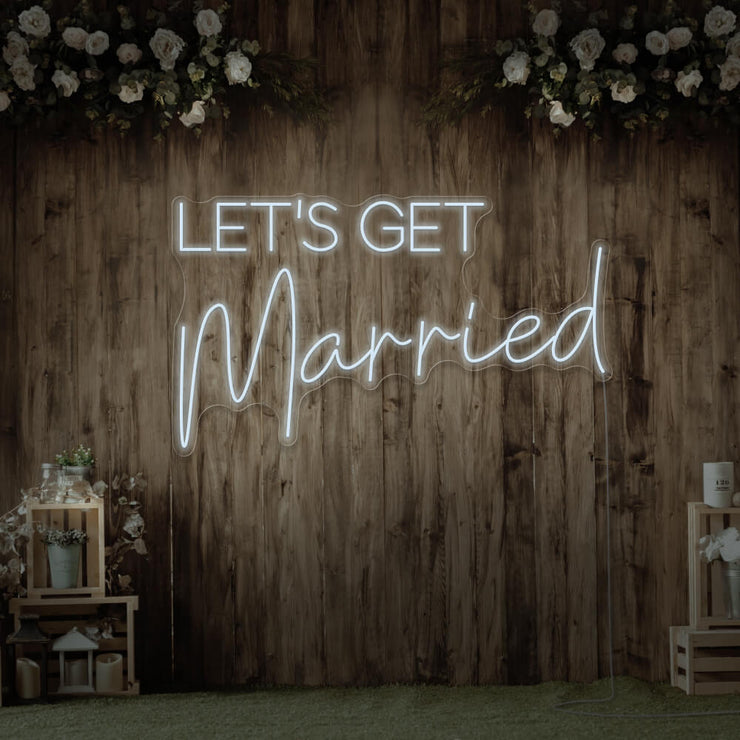 cold white lets get married neon sign hanging on timber wall