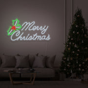 cold white merry chirstmas mistletoe neon sign hanging above couch next to christmas tree