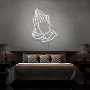 cold white praying hands neon sign hanging on bedroom wall