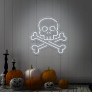 cold white skull bones neon sign with pumpkins on floor