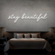 cold white stay beautiful neon sign hanging on bedroom wall