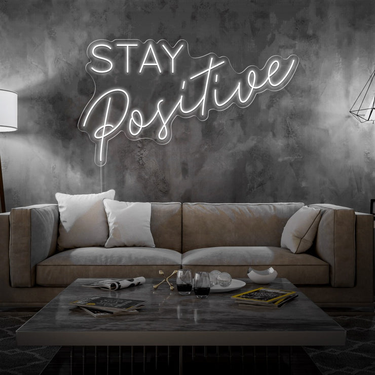 cold white stay positive neon sign hanging on living room wall