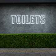 cold white toilets neon sign hanging on outdoor wall