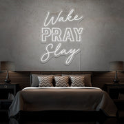 cold white wake pray slay neon sign hanging on bedroom wall