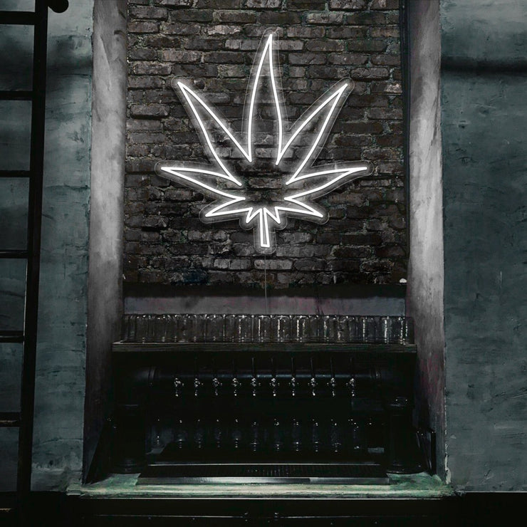 cold white weed leaf neon sign hanging on bar wall