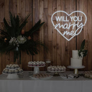 cold white will you marry me heart neon sign hanging on timber wall above dessert table