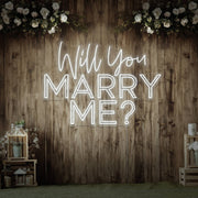 cold white will you marry me neon sign hanging on timber wall