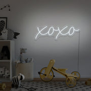 cold white xoxo neon sign hanging on kids bedroom wall