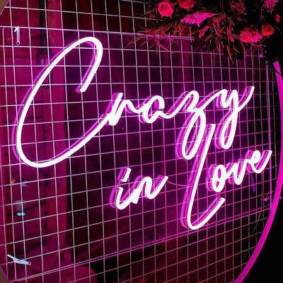hot pink crazy in love neon sign on white backdrop frame