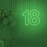 green 18 neon sign hanging on wall with balloons