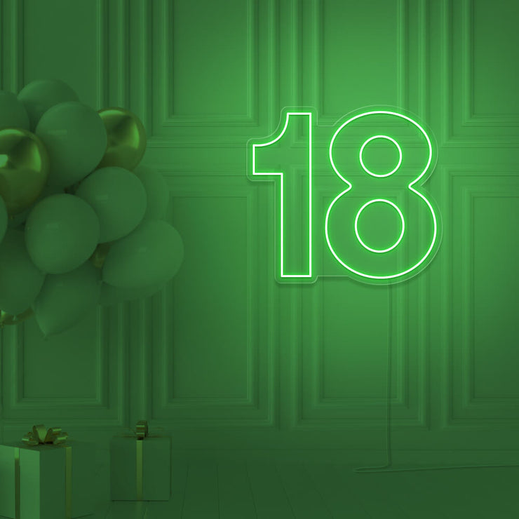 green 18 neon sign hanging on wall with balloons