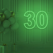 green 30 neon sign hanging on wall with balloons
