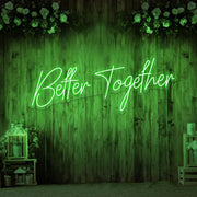green better together neon sign hanging on timber wall