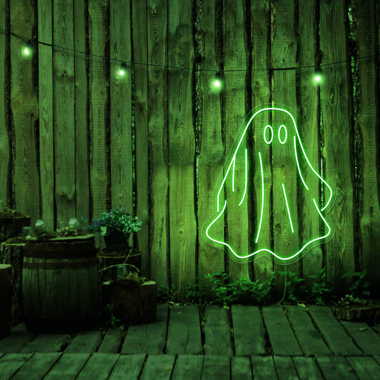 green draped ghost neon sign hanging on timber wall