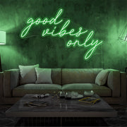 green good vibes only neon sign hanging on living room wall