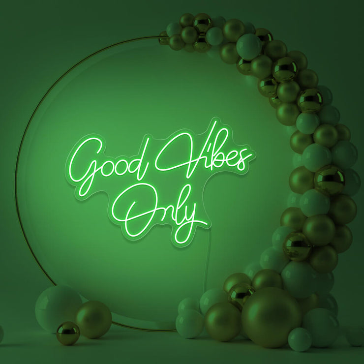 green good vibes only neon sign hanging inside balloon hoop backdrop
