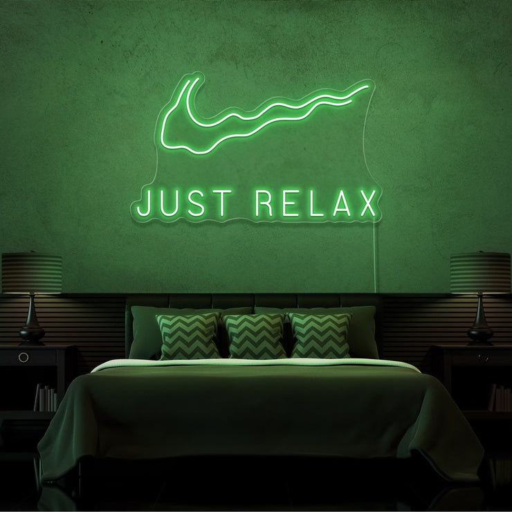 green just relax neon sign hanging on bedroom wall