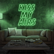 green kiss my airs neon sign hanging on living room wall