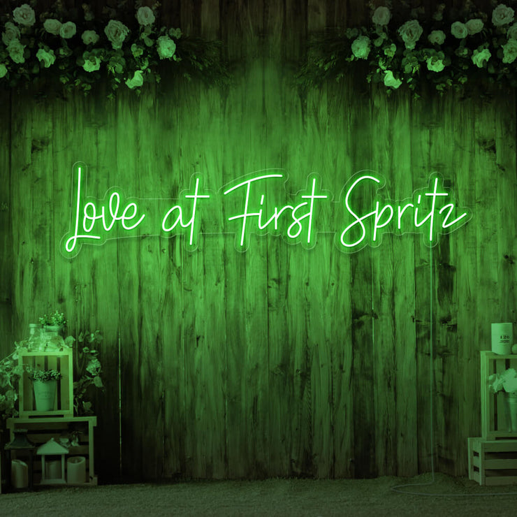 green love at first spritz neon sign hanging on timber wall