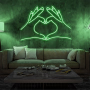 green love hands neon sign hanging on living room wall
