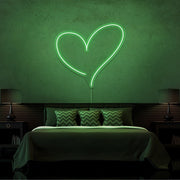 green love heart neon sign hanging on bedroom wall