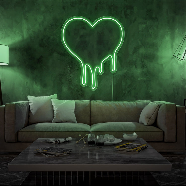 green melting heart neon sign hanging on living room wall