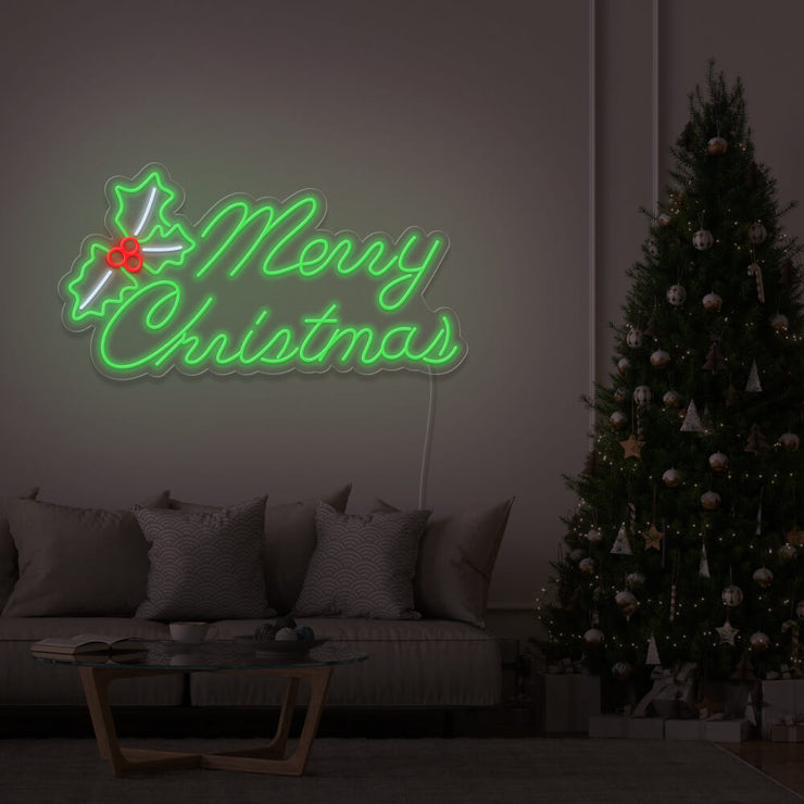 green merry chirstmas mistletoe neon sign hanging above couch next to christmas tree