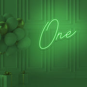 green 1st birthday neon sign hanging on wall with balloons