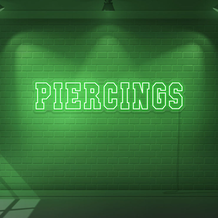 green piercings neon sign hanging on wall