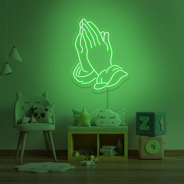 green praying hands neon sign hanging on kids bedroom wall