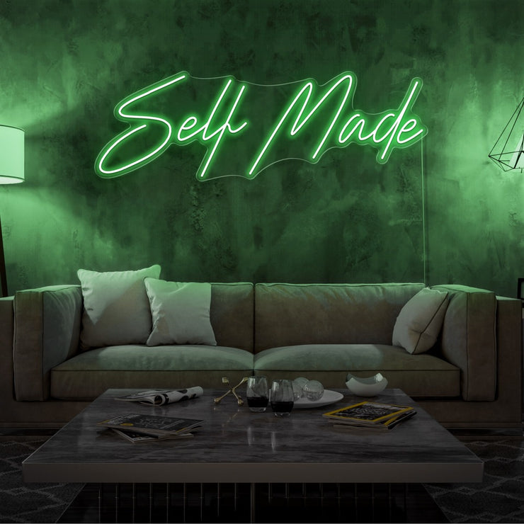 green self made neon sign hanging on living room wall