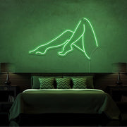 green sexy legs neon sign hanging on bedroom wall
