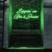 green sippin on gin and juice neon sign hanging on bar wall