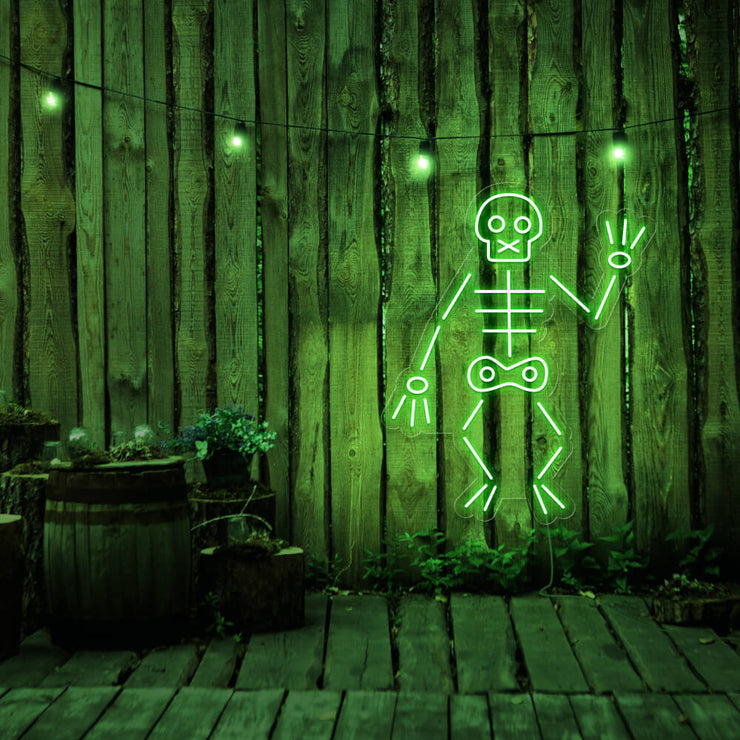 green skeleton neon sign hanging on timber fence