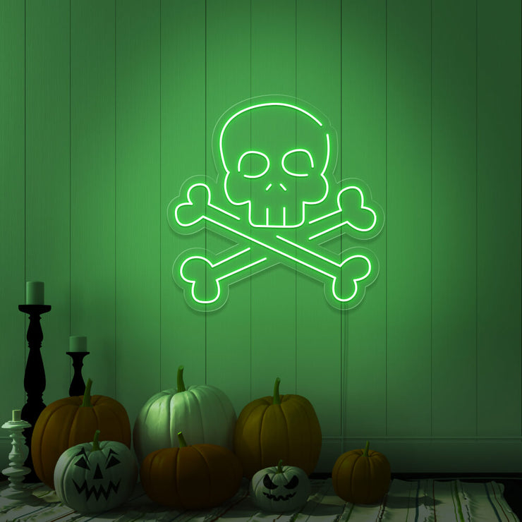green skull bones neon sign with pumpkins on floor