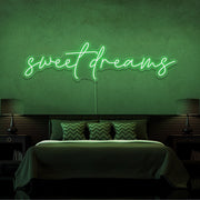 green sweet dreams neon sign hanging on bedroom wall