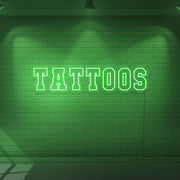 green tattoos neon sign hanging on wall
