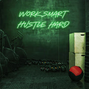 green work smart hustle hard neon sign hanging on gym wall