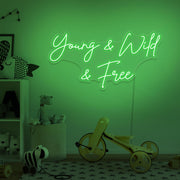 green young wild and free neon sign hanging on kids bedroom wall