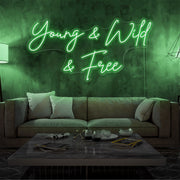 green young and wild and free neon sign hanging on living room wall