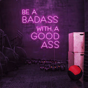 hot pink be a badass with a good ass neon sign hanging on gym wall