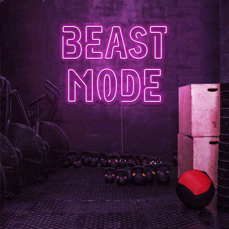 hot pink beast mode neon sign hanging on gym wall