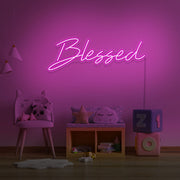 hot pink blessed neon sign hanging on kids bedroom wall