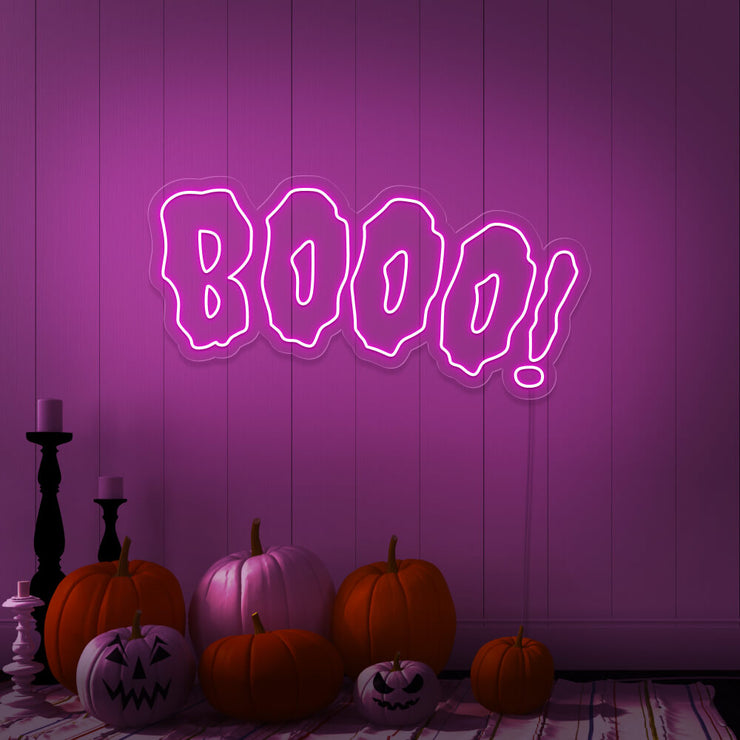 hot pink boo neon sign with halloween pumpkins on floor