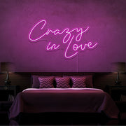 hot pink crazy in love neon sign hanging on bedroom wall