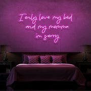 hot pink i only love my bed and my momma im sorry neon sign hanging on bedroom wall